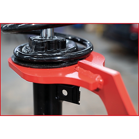 Nahaufnahme eines Teils einer Hebebühne: schwarze Feder, roter Arm, schwarzer Sockel.